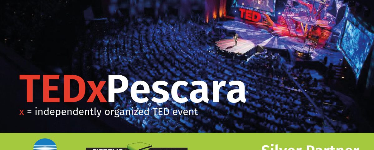 Palco e pubblico di un evento TEDx Pescara con il logo TEDx in primo piano e i partner Konica Minolta e Sistema Azienda.